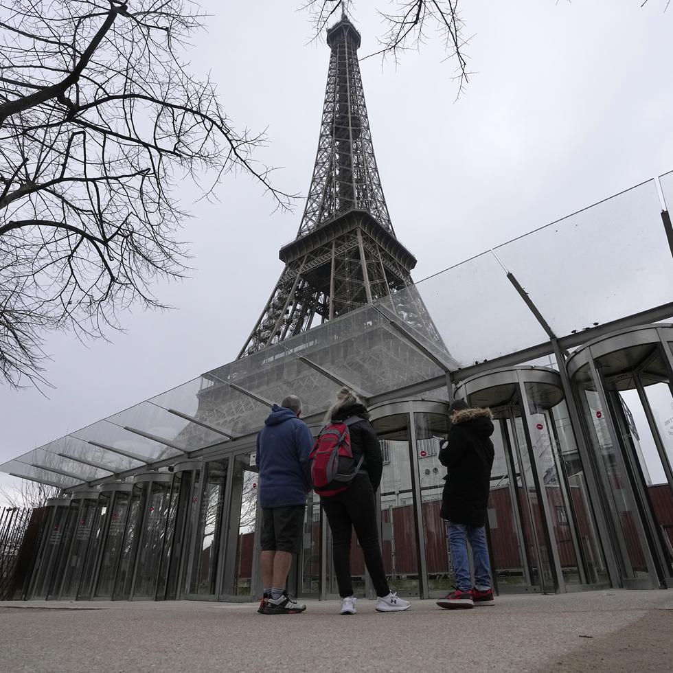 Visitantes frente las puertas cerradas de la Torre Eiffel, en París.