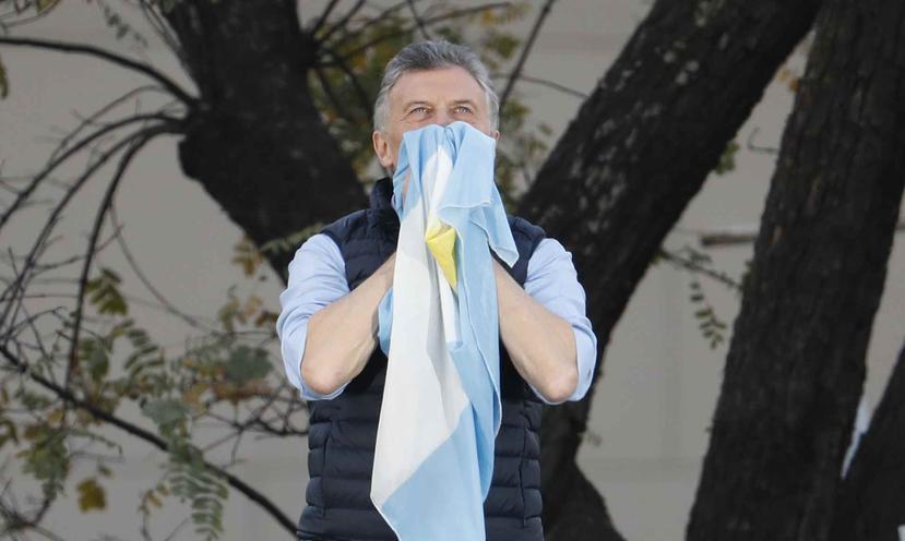 El presidente argentino Mauricio Macri sostiene una bandera nacional durante un evento en Buenos Aires, Argentina. (AP/Natacha Pisarenko)