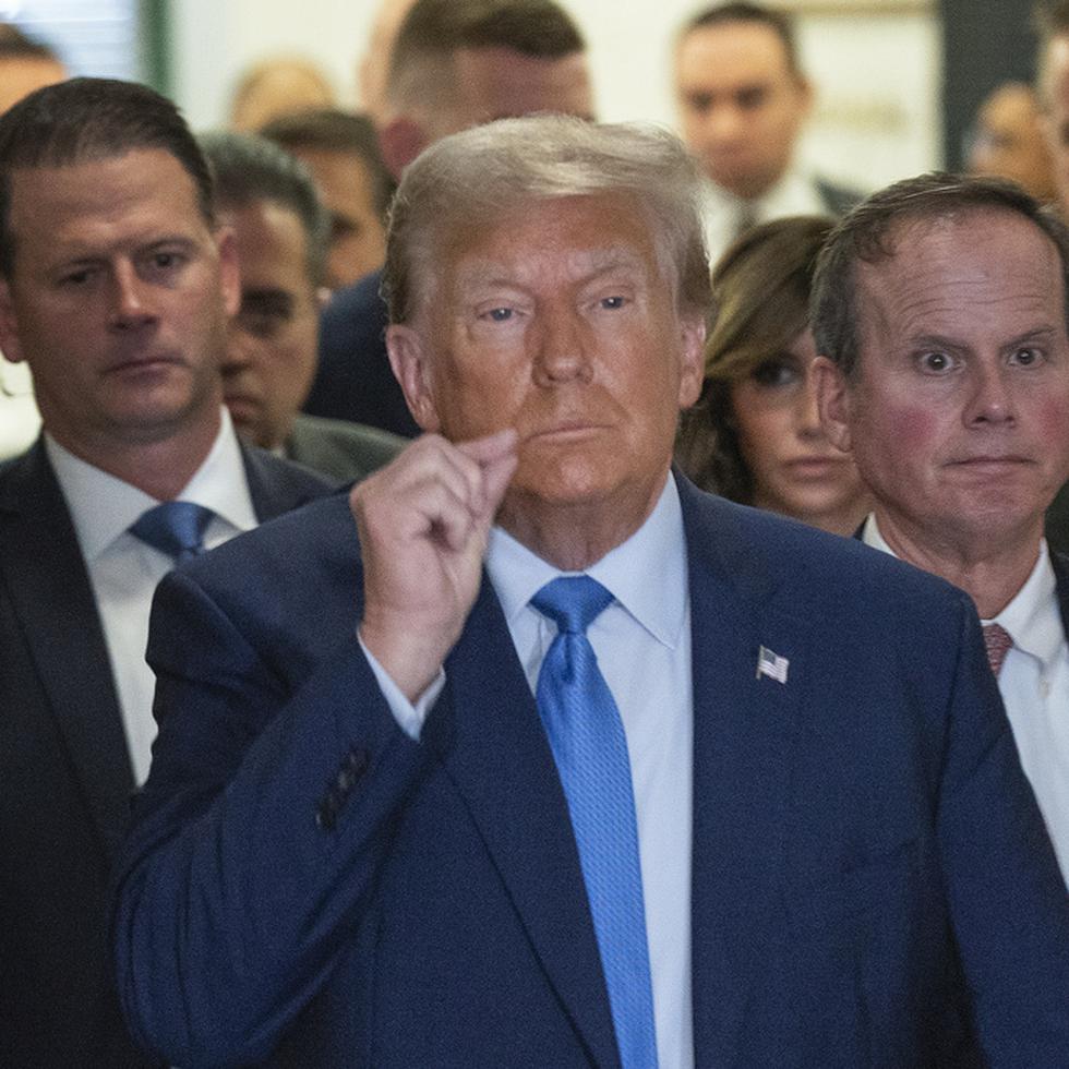 El expresidente de Estados Unidos, Donald Trump, hace una señal de labios sellados en las afueras de la corte suprema de Nueva York.