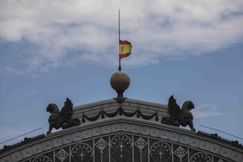 Una bandera de España ondea a media asta por el comienzo del luto por víctimas del COVID-19. (AP)