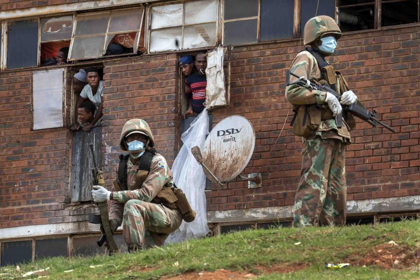 Fuerzas de la Defensa Nacional Sudafricana patrullan un hostal de hombres en el municipio de Alexandra, al oriente de Johannesburgo. (AP)