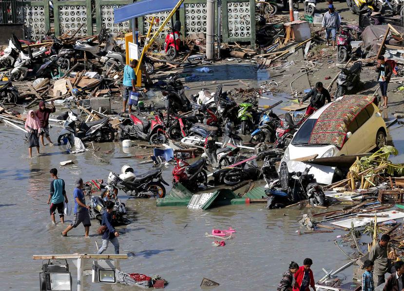 Personas evalúan los daños fuera de un centro comercial tras el terremoto y tsunami que azotó Palu, en Célebes Central, Indonesia. (AP / Tatan Syuflana)