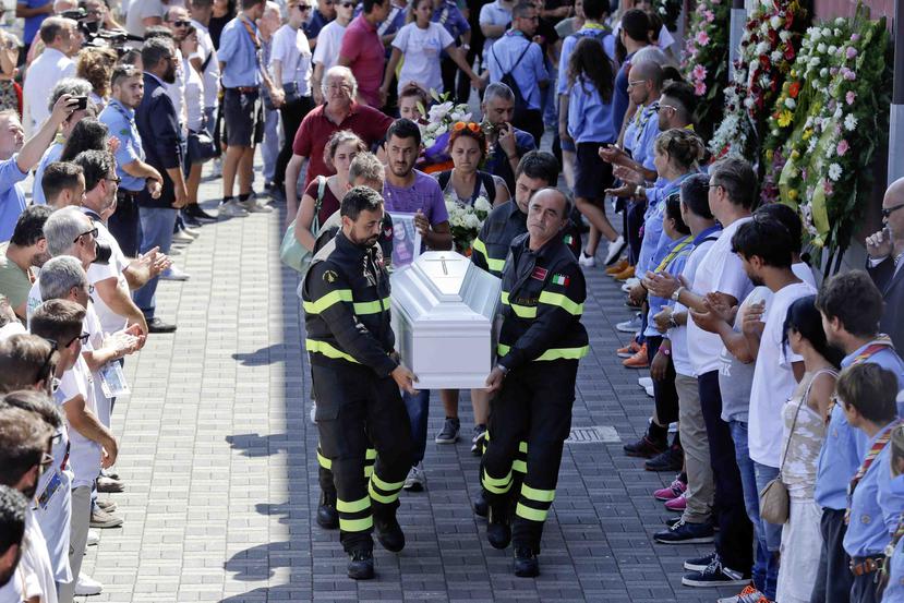 Numerosas personas despedían con lágrimas a Giulia y 34 fallecidos más con un funeral de estado. (AP Photo/Gregorio Borgia)