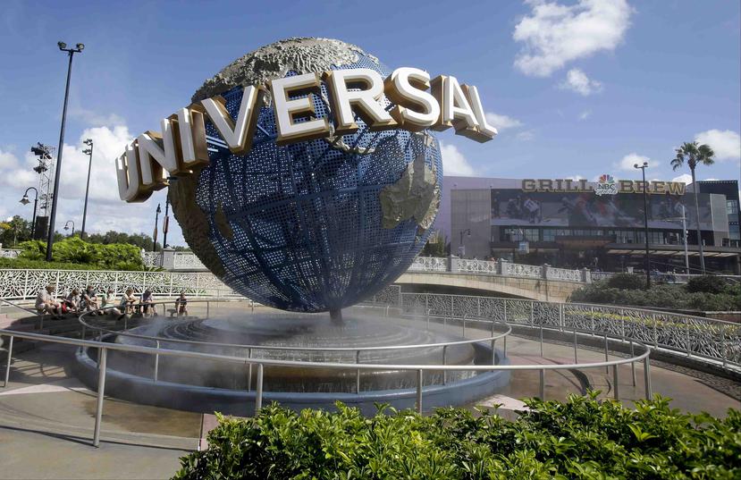 Fotografía de archivo del 22 de octubre de 2015 de visitantes de un parque temático descansado con rocío de agua en el globo en Universal Studios City Walk en Orlando, Florida. (AP)