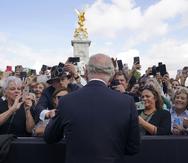 Britain's King Charles III, back to camera, greets well-wishers as he walks by the gates of Buckingham Palace following Thursday's death of Queen Elizabeth II, in London, Friday, Sept. 9, 2022. King Charles III, who spent much of his 73 years preparing for the role, planned to meet with the prime minister and address a nation grieving the only British monarch most of the world had known. He takes the throne in an era of uncertainty for both his country and the monarchy itself. (Yui Mok/Pool Photo via AP)