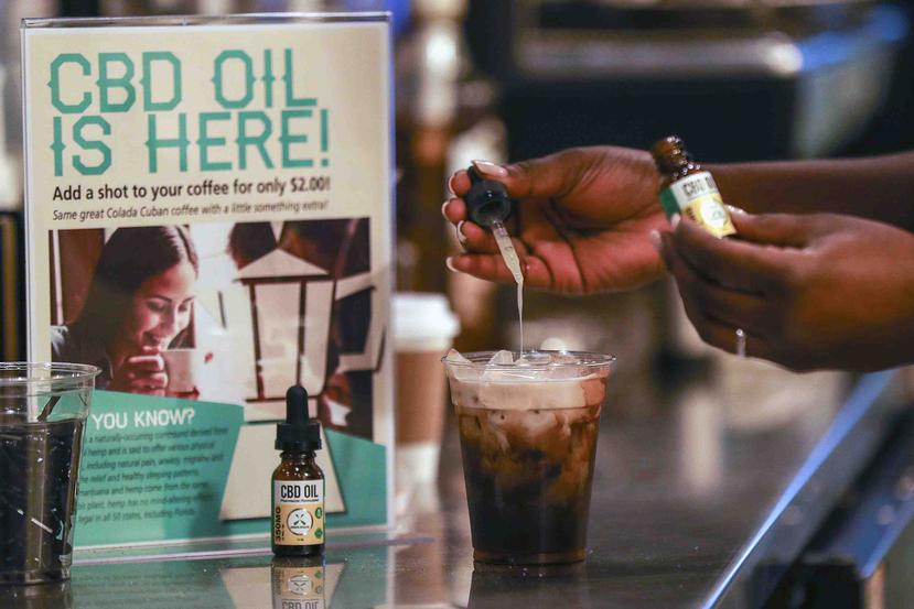 Un cliente deja caer unas gotas de CBD en su café en un bar de Fort Lauderdale, Florida, el 4 de enero del 2018. Un cartel informa que "¡Aquí se vende CBD!".  (AP)
