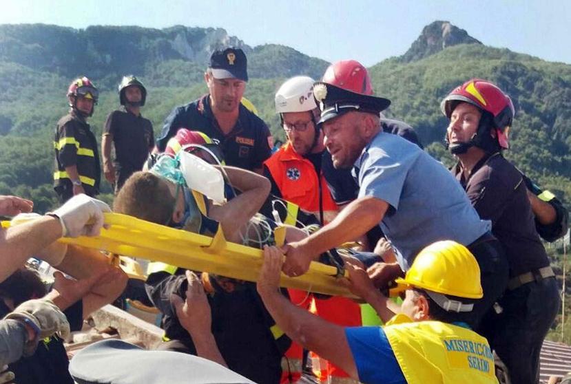 Los bomberos realizan el rescate de uno de los niños tras el terremoto reportado en la isla de Ischia. (AP)