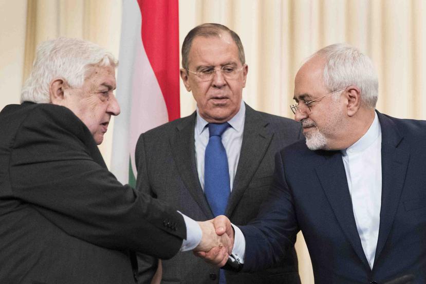 Al centro, el ministro de exteriores de Rusia Sergey Lavrov, mientras los cancilleres de Siria, Walid Muallem, e Irán, Javad Zarif, se dan la mando después de una conferencia de prensa. (AP)