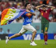 Un aficionado irrumpe en la cancha con la bandera arcoíris durante el partido del Grupo H entre Portugal y Uruguay.