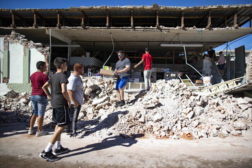 Vecinos de la ferretería Elimelmar, en Guánica, ayudaron a su dueña y empleados a remover el material del interior de la estructura que se afectó seriamente.
