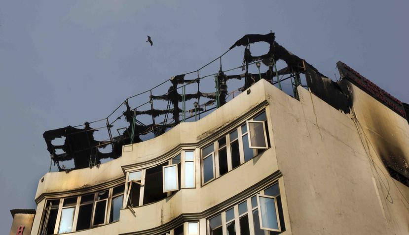Un pájaro sobrevuela el hotel Arpit Palace, donde un incendio registrado de madrugada dejó más de una docena de muertos, en el vecindario de Karol Bagh, en Nueva Delhi, India, el 12 de febrero de 2019. (AP/Manish Swarup)