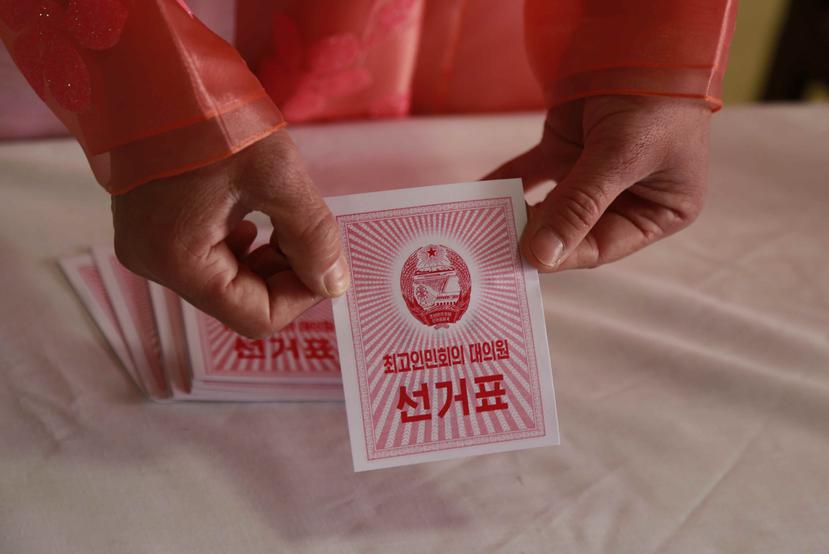 Un trabajador electoral muestra una boleta durante una elección, en un centro de votación en Pyongyang, Corea del Norte, el 10 de marzo de 2019. (AP Foto/Dita Alangkara)