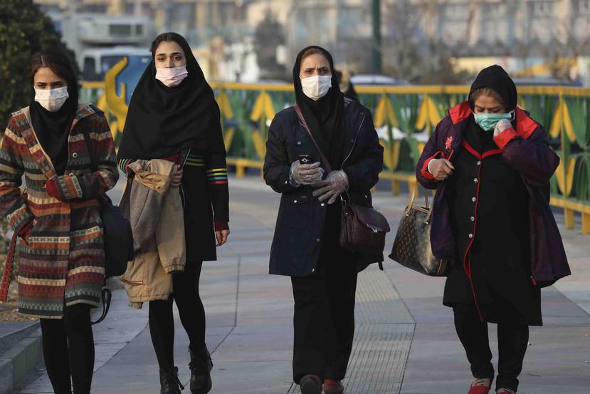 Varias mujeres caminan con mascarillas en una vereda en el oeste de Teherán, Irán. (AP)