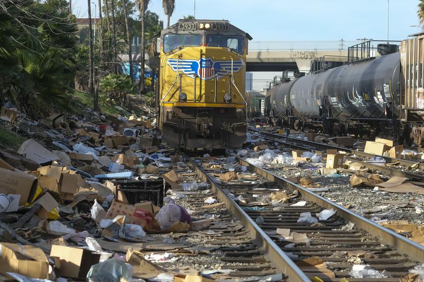 Cajas y paquetes rotos pueden verse en una sección de las vías del tren de Union Pacific, el viernes 14 de enero de 2022, en el centro de Los Ángeles.