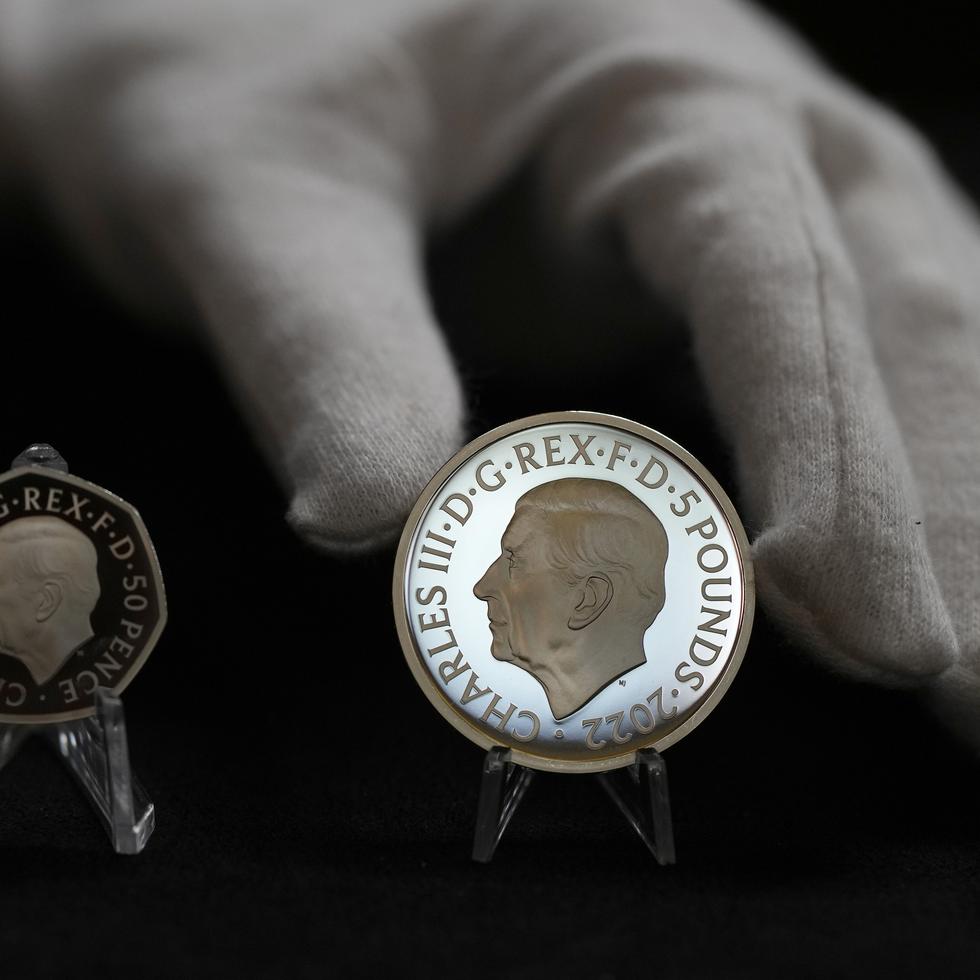 Dos monedas nuevas muestran el retrato oficial del rey Charles III: una de 50 peniques a la izquierda y una de 5 libras a la derecha.