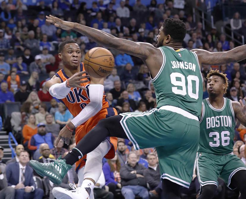 Russell Westbrook pasa un balón ante la presión de Amir Johnson, de los Celtics. (AP)