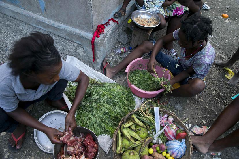 Unos vendedores preparan los ingredientes para hacer sopa en Puerto Príncipe, Haití. (AP/Dieu Nalio Chery)