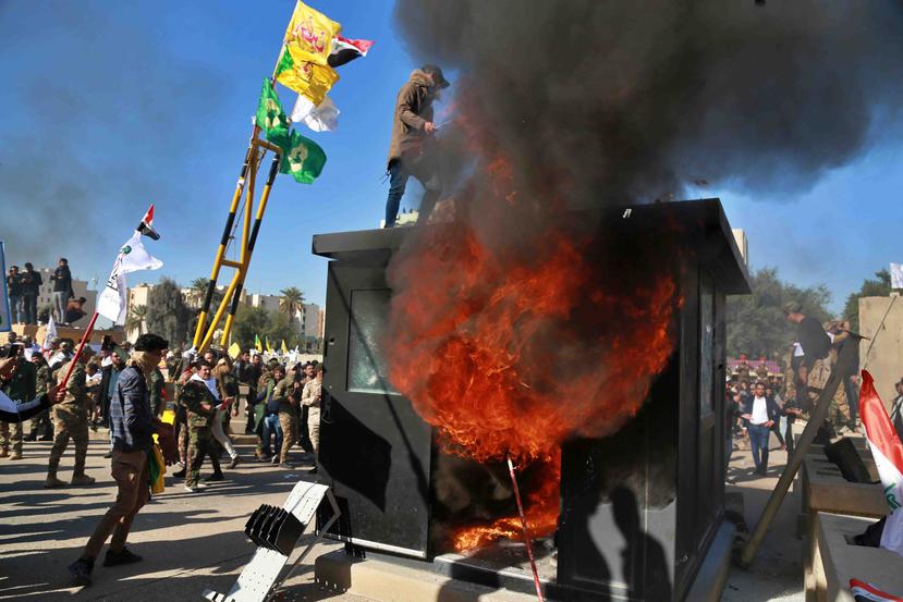 Manifestantes queman una caseta enfrente de la embajada de Estados Unidos en Bagdad, Irak. (AP)