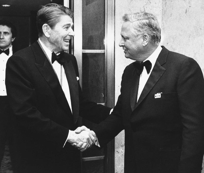 En esta fotografía de archivo del 26 de enero de 1985, el presidente Ronald Reagan, a la izquierda, saluda al magnate hotelero Barron Hilton, en el Capitolio en Washington, para asistir a la reunión anual del Club Alfalfa. (AP/Budd Gray, Archivo)