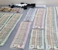 Foto suministrada por el Negociado de la Policía que muestra parte del dinero y las armas de fuego ocupadas en dos residencia en Ponce.
