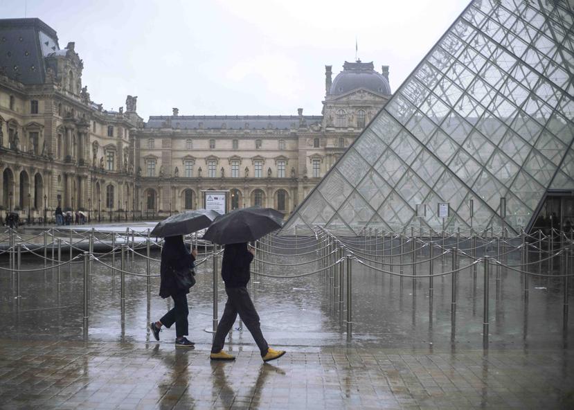 Un grupo de turistas esperan para entrar al Museo Louvre. (AP)