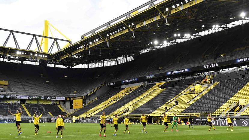 Los jugadores del Borussia Dortmund festejan en el estadio vacío, al finalizar un encuentro de la Bundesliga ante Schalke, que marcó la reanudación de la campaña en medio de la pandemia de coronavirus. (AP / Martin Meissner)