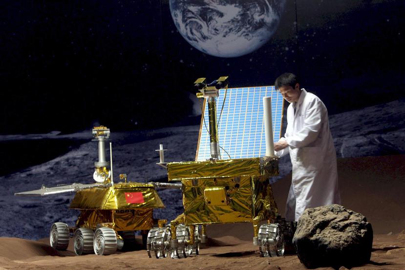 Imagen de archivo de un investigador chino trabajando en un prototipo de vehículo lunar en una superficie simulada.