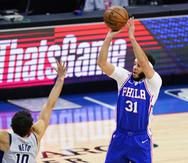 Seth Curry de los 76ers de Filadelfia tira el balón superando a Raúl Neto de los Wizards de Washington en el juego 5 de la serie de primera ronda de postemporada.