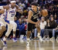 El base de los Spurs de San Antonio Tre Jones avanza mientras lo persigue el alero de los 76ers de Filadelfia Danuel House Jr. en el encuentro de la NBA del sábado 22 de octubre del 2022 en Filadelfia.