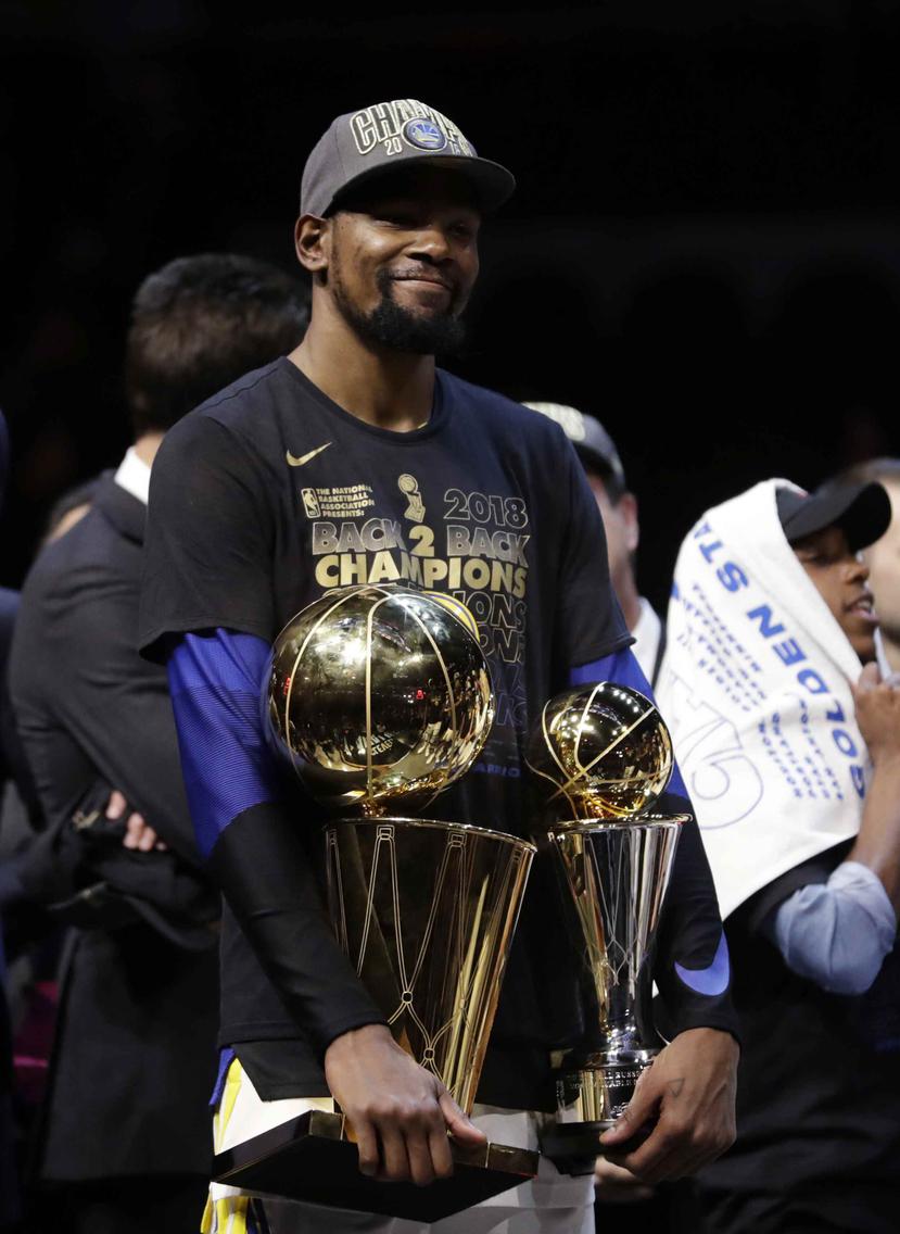 Kevin Durant carga con los trofeos de campeonato de la NBA y del JMV de la final. (AP)
