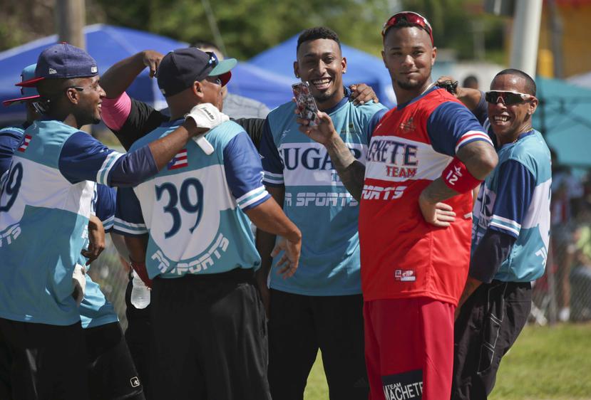 Machete Maldonado -derecha- y Edwin Díaz comparten con otros jugadores en la actividad que se celebró en el barrio Jardines de  Esperanza de Naguabo.