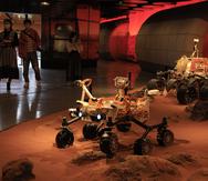 Visitantes pasan por un recinto en el que se exhiben sondas rodantes que simulan estar en Marte en una exposición en Beijing el viernes 14 de mayo de 2021.