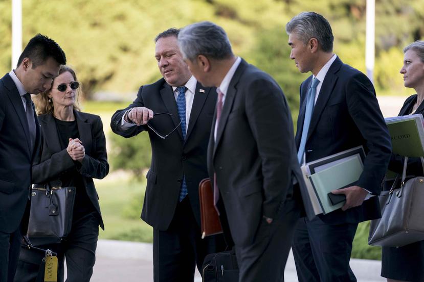 El secretario de Estado de Estados Unidos, Mike Pompeo, rodeado por funcionarios estadounidenses y norcoreanos, mira su reloj. (AP)