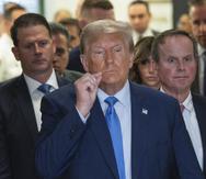 El expresidente de Estados Unidos, Donald Trump, hace una señal de labios sellados en las afueras de la corte suprema de Nueva York.