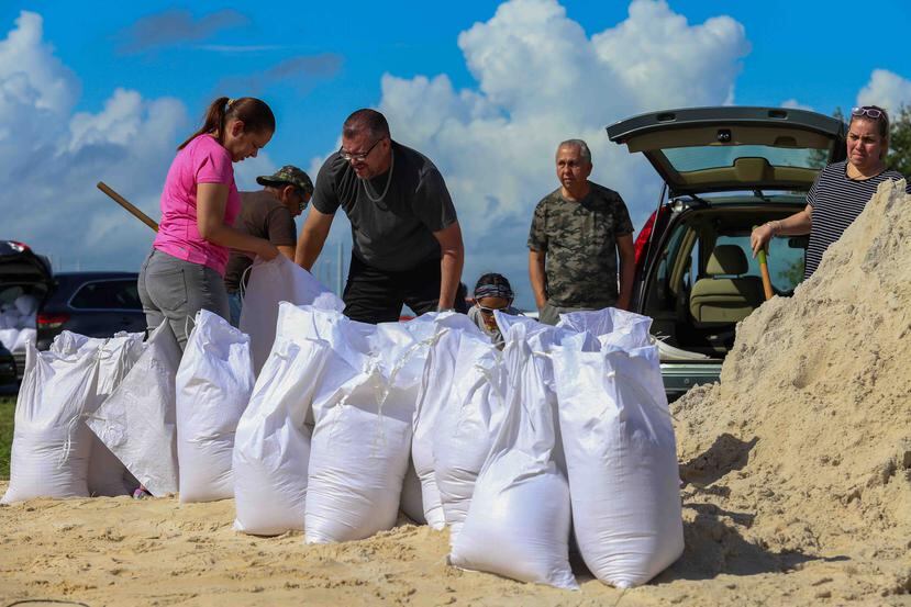 Personas llenan sacos de arena en Florida.