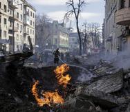 Bomberos apagan llamas ante un edificio de apartamentos tras un ataque ruso en Járkiv, Ucrania, el 14 de marzo de 2022.