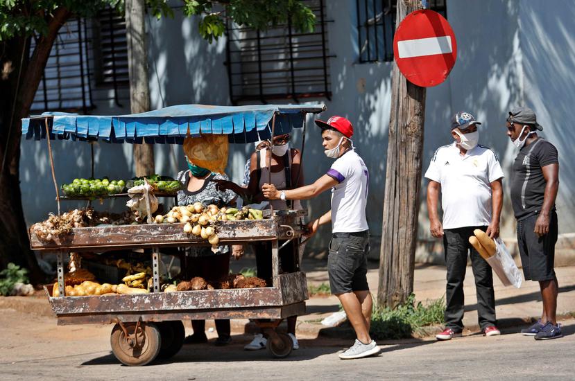 Varias personas hablan junto a un carretillero que vende productos agrícolas este martes, en La Habana. (Agencia EFE)