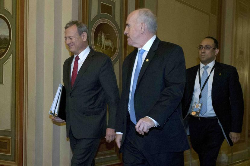 El presidente de la Corte Suprema John Roberts acompañado de sargentos de armas del Senado federal. (AP)