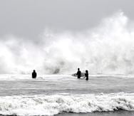 Surfistas aprovechan las olas durante una tormenta en Venice Beach, en Los Ángeles, el sábado 14 de enero de 2023.