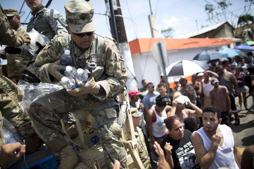 Un militar de la Guardia Nacional reparte agua en Barrio Obrero.