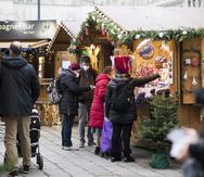 Varias personas, con mascarilla para protegerse del coronavirus, visitan un marcado navideño en Austria, Viena, el 17 de noviembre de 2021.