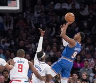 El base de los Knicks de Nueva York RJ Barrett lanza el balón sobre el base de los Clippers de Los Ángeles Reggie Jackson.