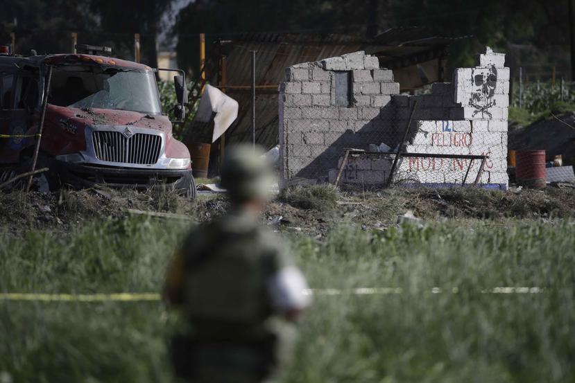 Un soldado protege el perímetro en torno a los restos de varios talleres pirotécnicos luego de explosiones, en Tultepec, México. (AP)