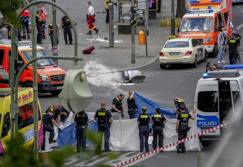 Oficiales cubren el cuerpo de la persona que falleció tras haber sido atropellada en una zona comercial de Berlín, Alemania.