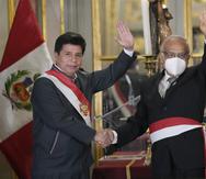 El presidente de Perú, Pedro Castillo, a la izquierda, saluda junto a su nuevo jefe de gabinete, Aníbal Torres, durante la juramentación del nuevo gabinete, en el palacio de gobierno en Lima.