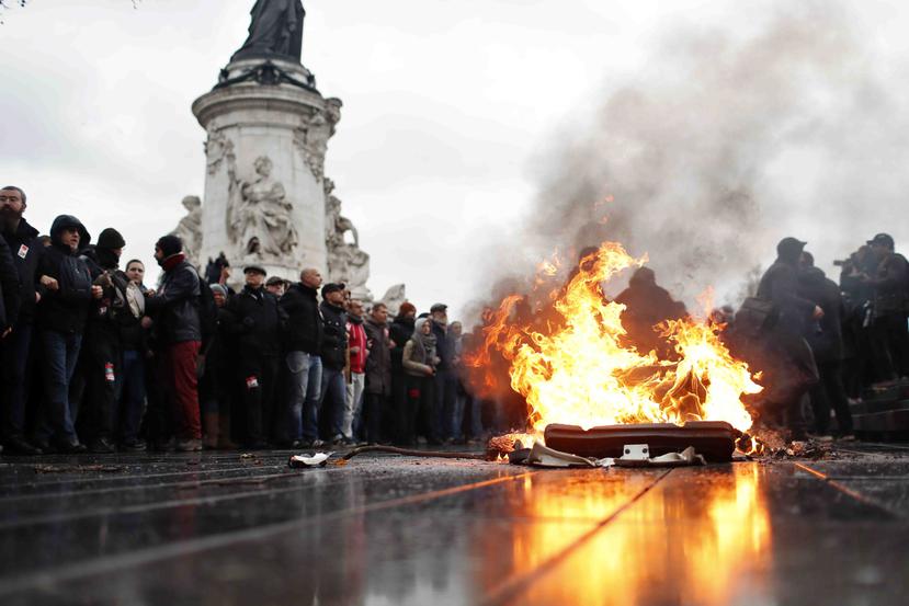 Un contenedor de basura arde durante una manifestación de estudiantes en París. (AP)
