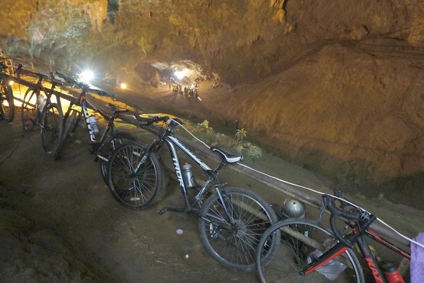 Bicicletas dejadas por un grupo de niños desaparecidos están recargadas contra un barandal en la entrada de una caverna en Chiang Rai, Tailandia. (Thai News Pix vía AP)
