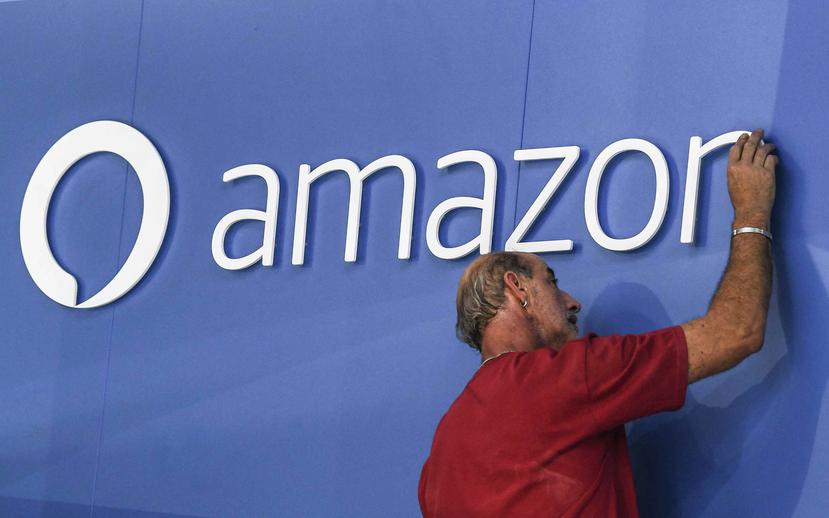 Un trabajador ajusta el logo de Amazon. (EFE)