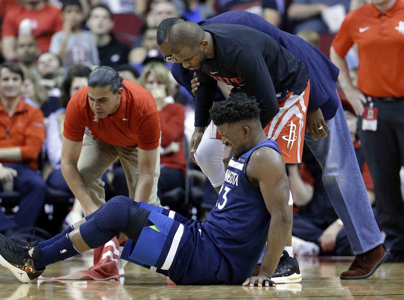Jimmy Butler reacciona luego de lastimarse la rodilla durante el partido contra los Rockets. (AP)
