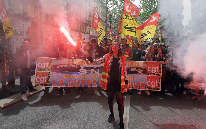 Una persona sostiene una luz de bengala en su mano mientras participa en la manifestación contra la reforma laboral en Francia. (AP)